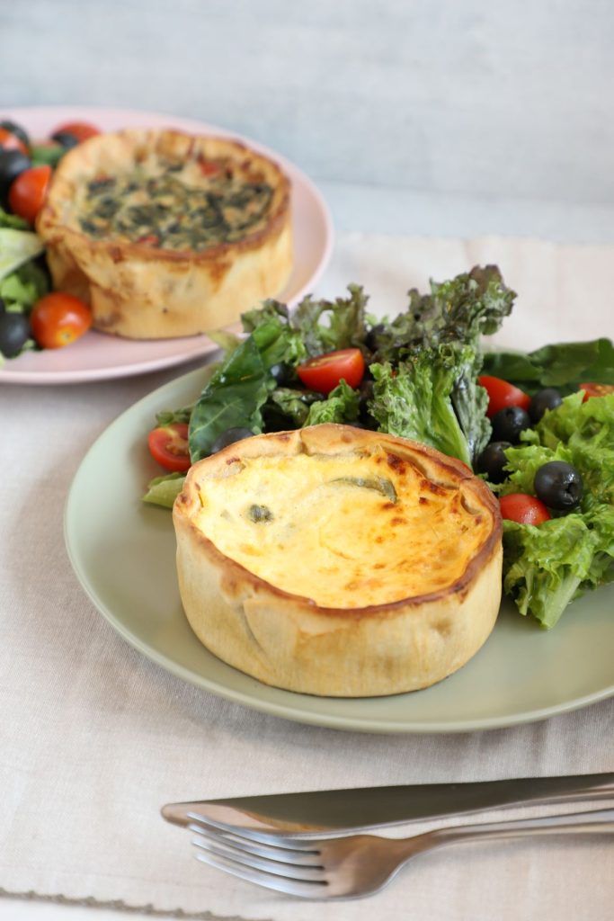 Tarta salada de Cory acompañada de ensalada fresca con tomates cherry y aceitunas.